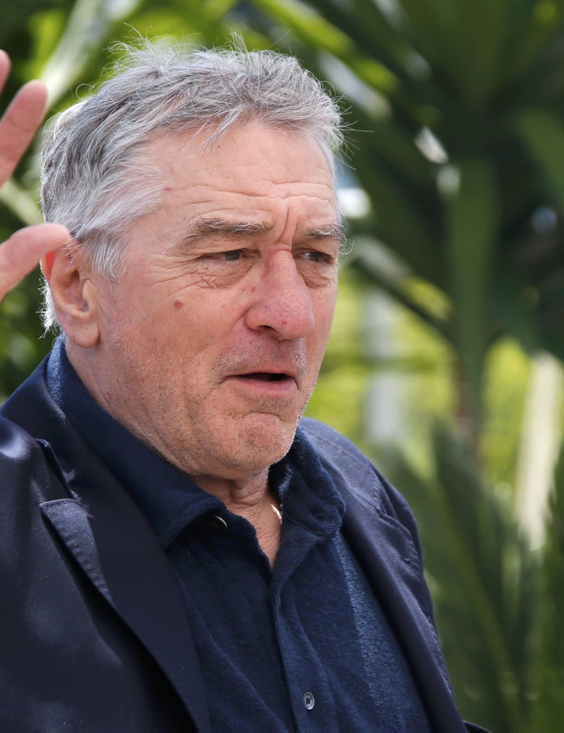 Cast member Robert De Niro waves as he arrives at a photocall for the film "Hands of stone" out of competition at the 69th Cannes Film Festival in Cannes