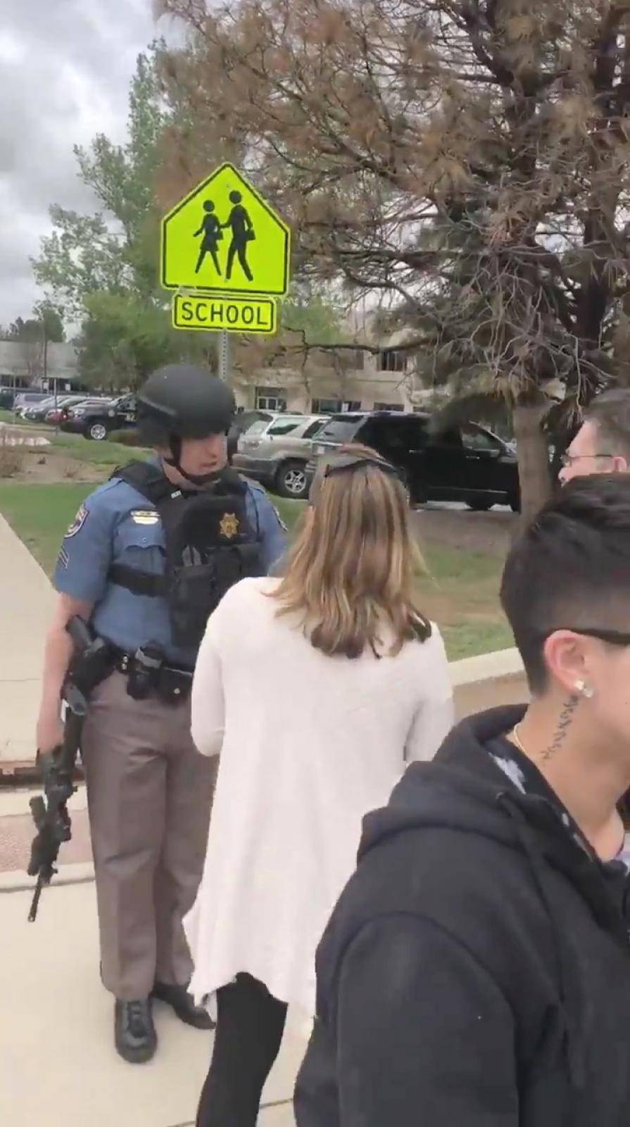 A police officer reassures people waiting outside near the STEM School during a shooting incident in Highlands Ranch, Colorado, U.S. in this May 7, 2019 still frame obtained via social media video