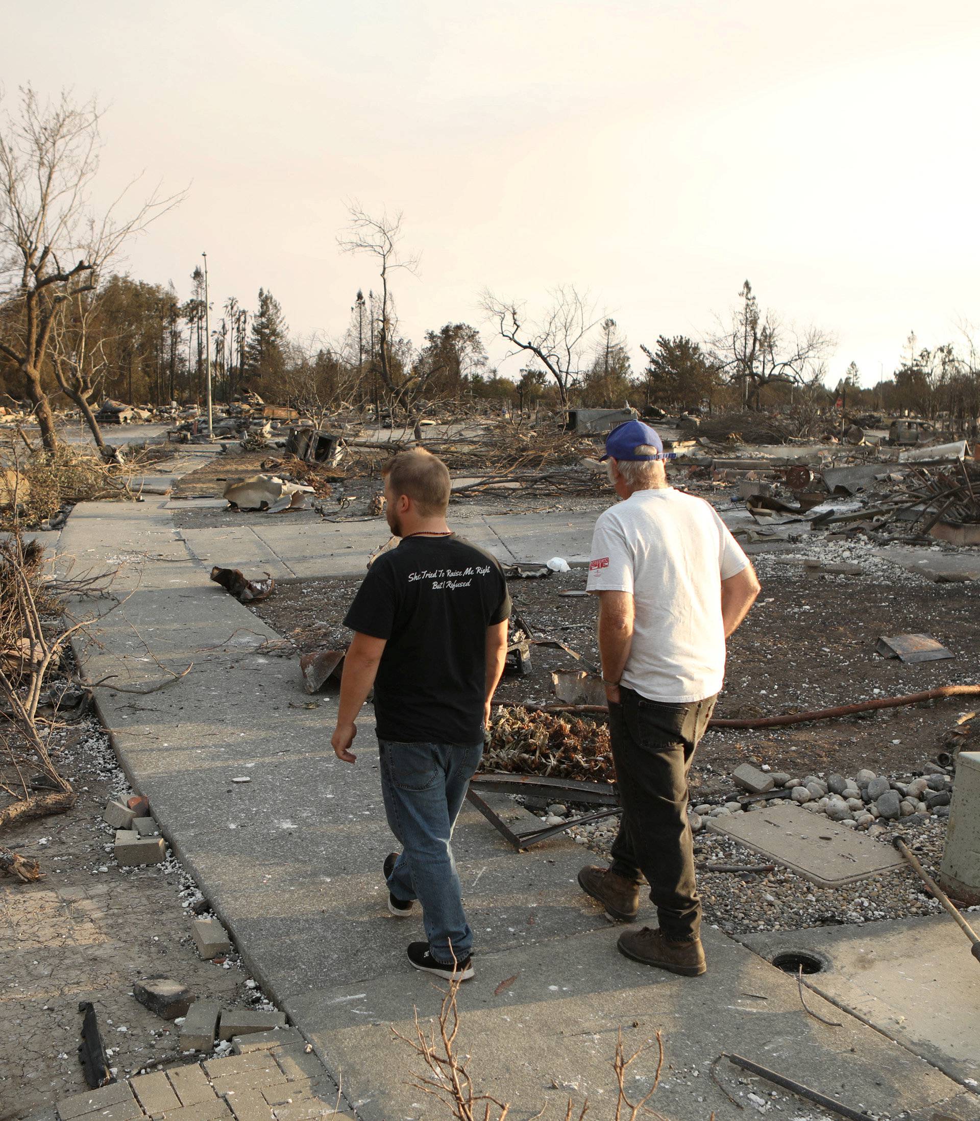 Area residents walk through a neighborhood destroyed by wildfire in Santa Rosa, California, U.S.