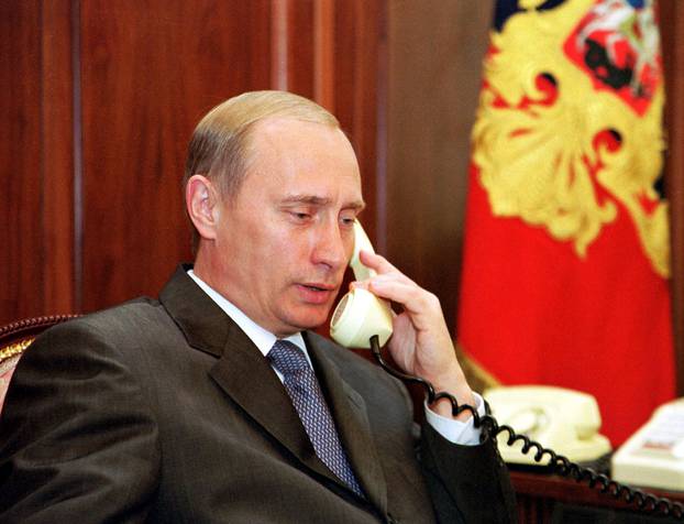 FILE PHOTO: Russian President Vladimir Putin speaks on the phone in his Kremlin office in Moscow
