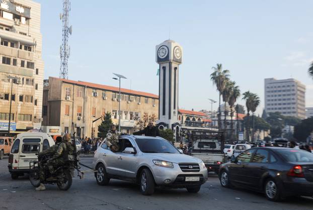 Syrian rebels fighters in vehicles celebrate in Homs