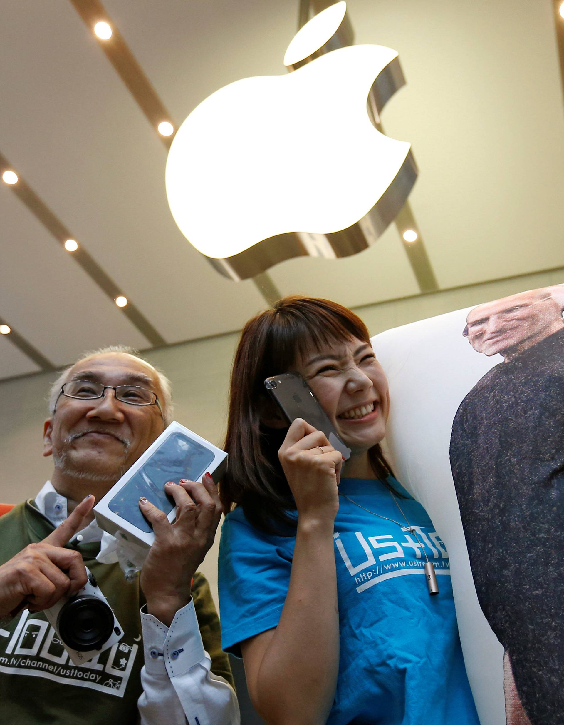 Customers pose with their new Apple's iPhone 7 after purchasing them at the Apple Store at Tokyo's Omotesando shopping district