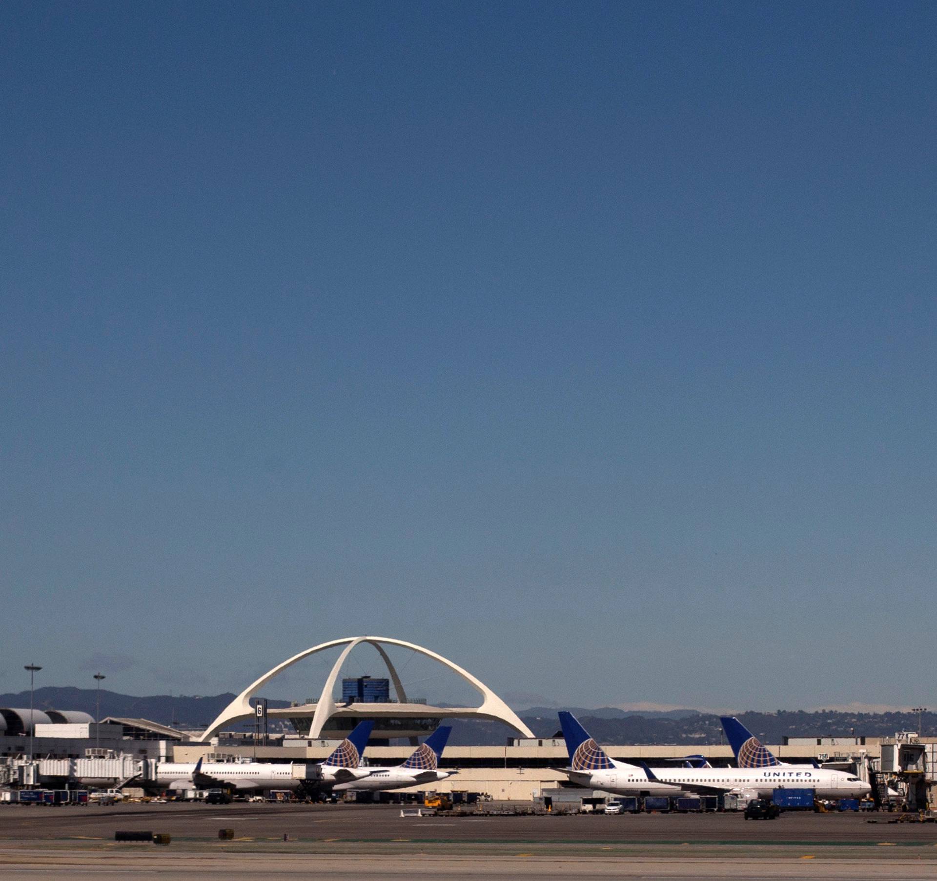 United Airlines planes are seen in the foreground of the Los Angeles International Airport and its air traffic control tower