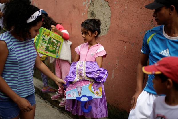 Children attend a toy distribution program with Miguel Pizarro, deputy of the MUD, in a school at the slum of Petare in Caracas