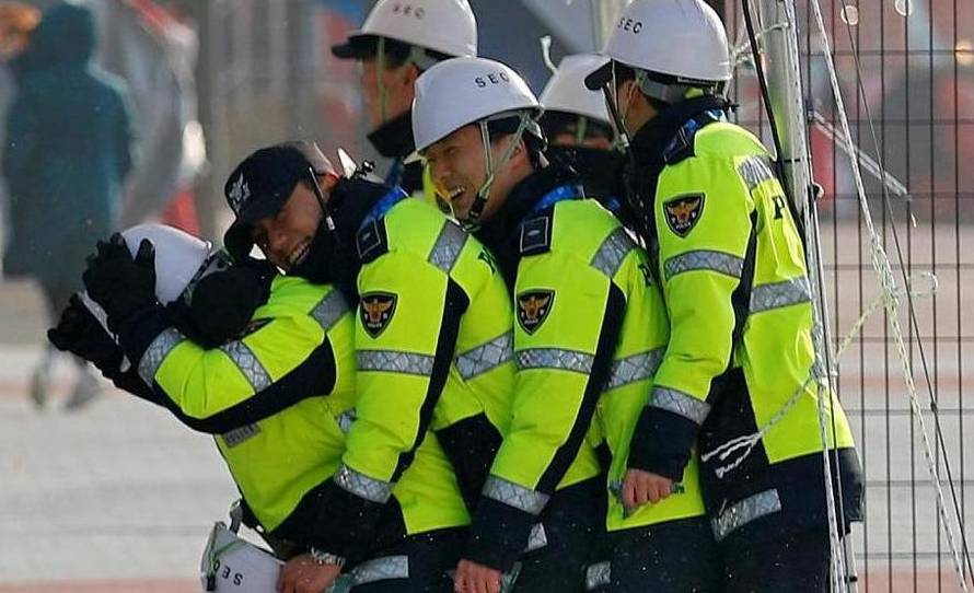 Security personnel react during windy weather
