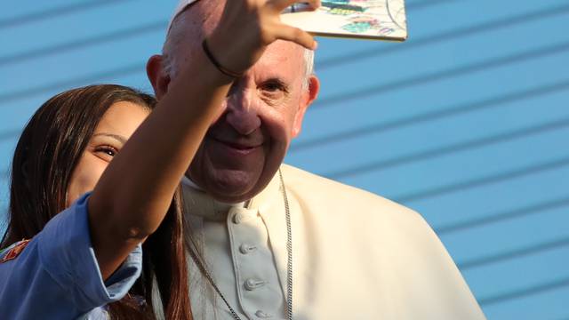 Pope Francis takes a selfie with a faithful as he meets with young people at the Politeama square in Palermo