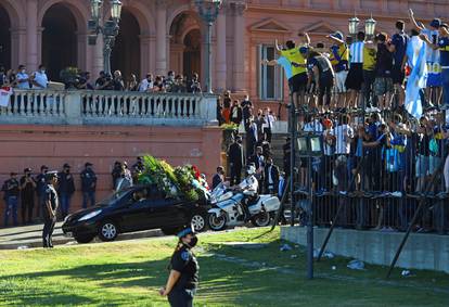 People react as the funeral procession with the casket of soccer legend Diego Maradona leaves the presidential palace Casa Rosada in Buenos Aires