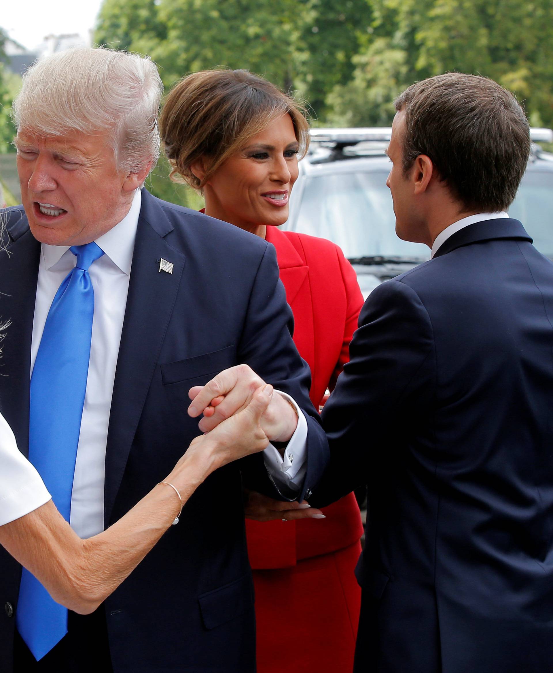 French President Emmanuel Macron greets US First Lady Melania Trump while his wife Brigitte Macron welcomes US President Donald Trump at Les Invalides museum in Paris