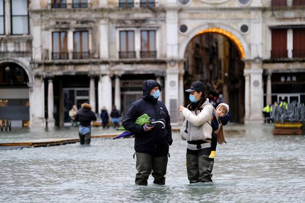 People walk in flooded St. Mark