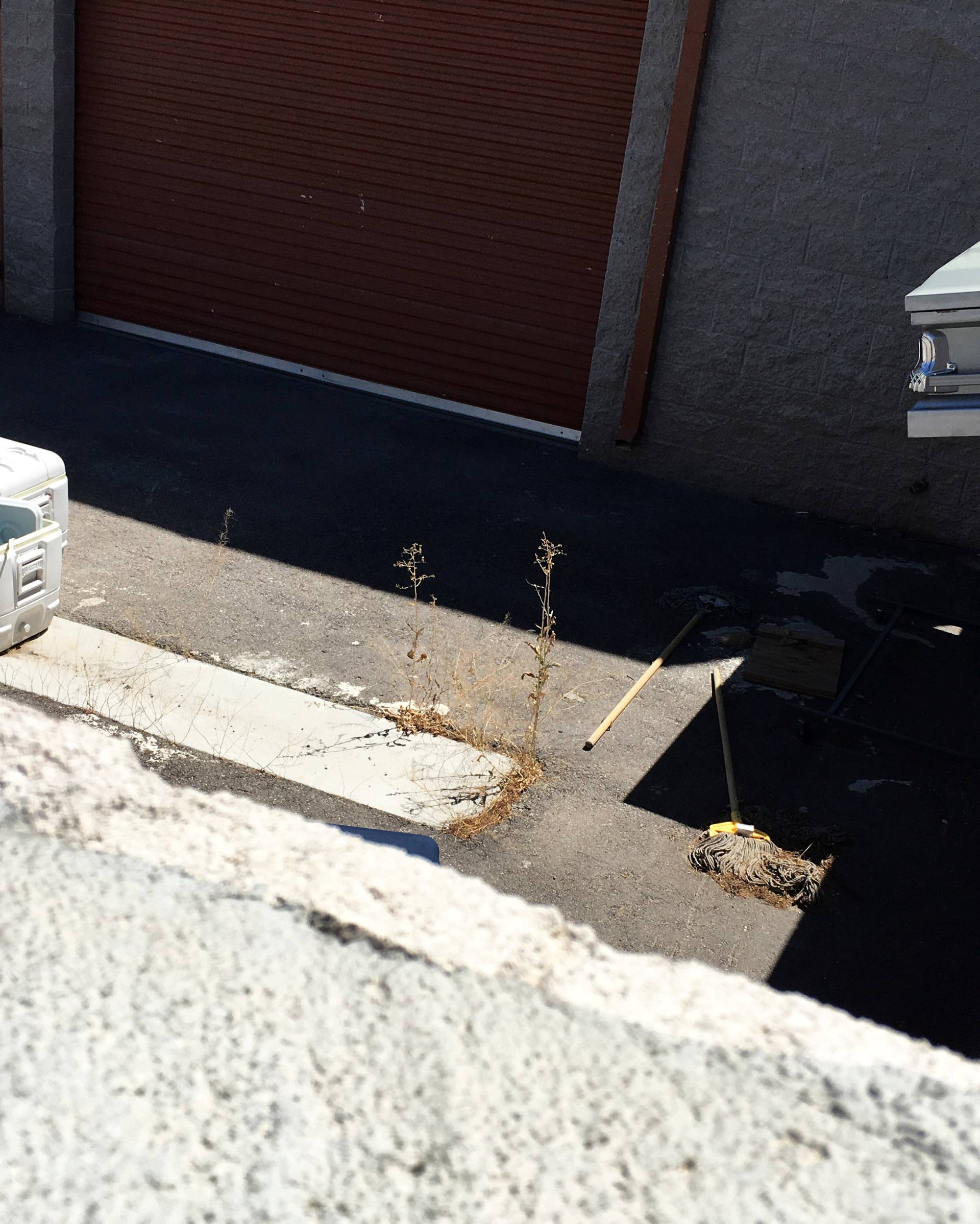 A coffin, mops and coolers used to transport body parts lie in an abandoned courtyard outside a warehouse  in suburban Las Vegas