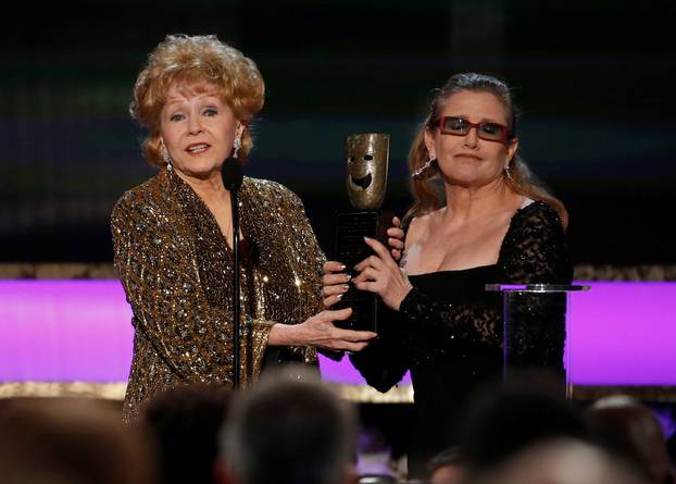 FILE PHOTO: Actress Debbie Reynolds accepts the life achievement award from her daughter actress Carrie Fisher at the 21st annual Screen Actors Guild Awards in Los Angeles