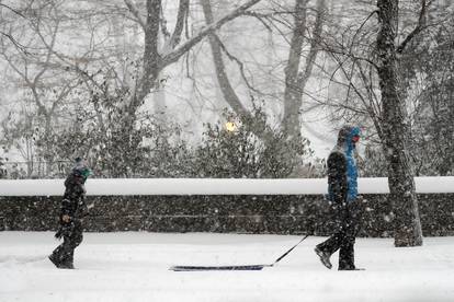 Man pulls sled in heavy falling snow in Manhattan during winter storm in New York