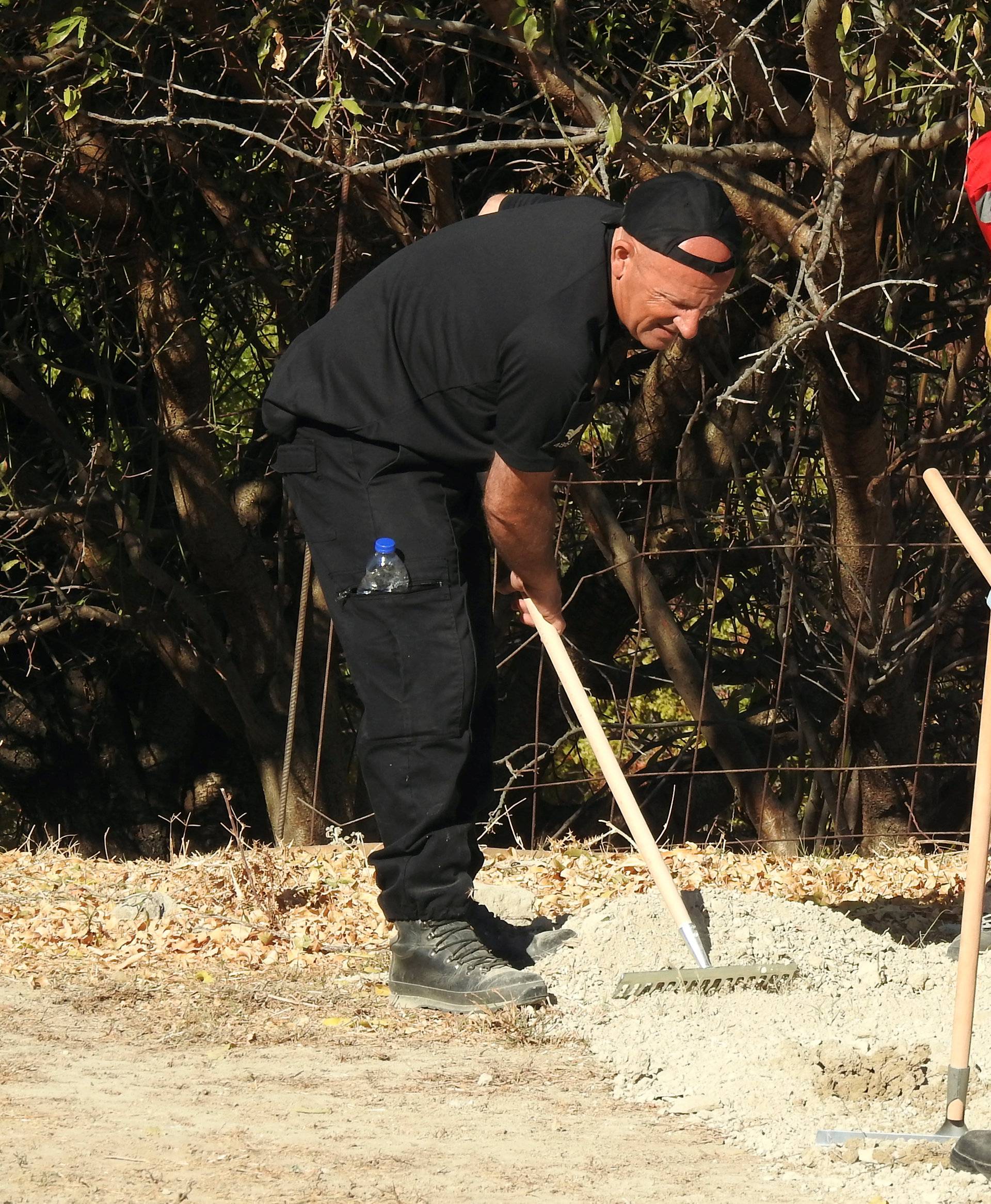 South Yorkshire police officer and members of the Greek rescue service investigate the ground while excavating a site during an investigation for Ben Needham on the island of Kos