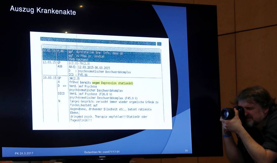 A photographer takes pictures of a screen during news conference of Guenter Lubitz in Berlin