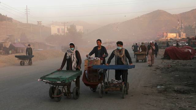 Afghan men push their hand carts in the early morning in Kabul