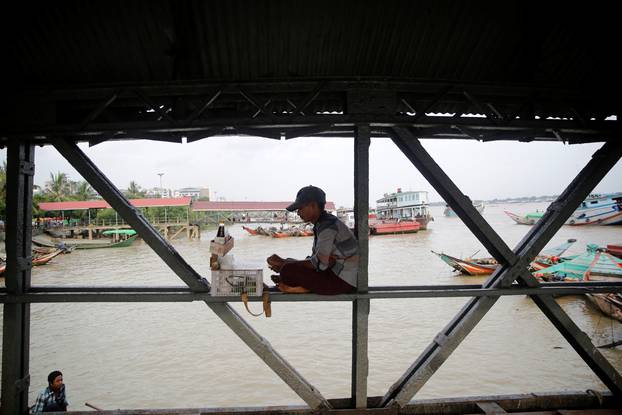 A vendor sits on a jetty as he sells betel nuts on Hlaing river in Yangon, Myanmar 