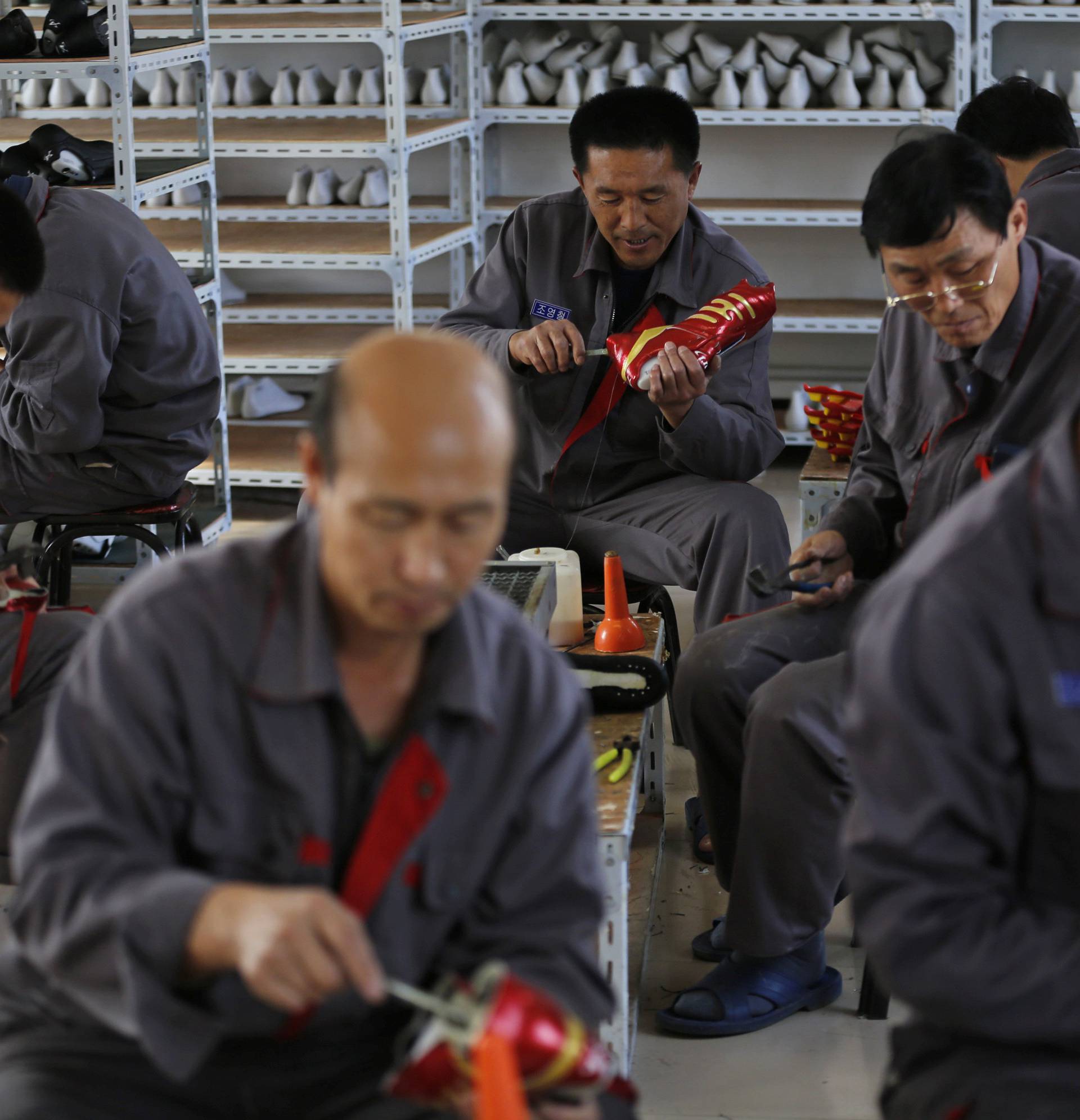 FILE PHOTO - North Korean workers make soccer shoes inside a temporary factory at a rural village on the edge of Dandong