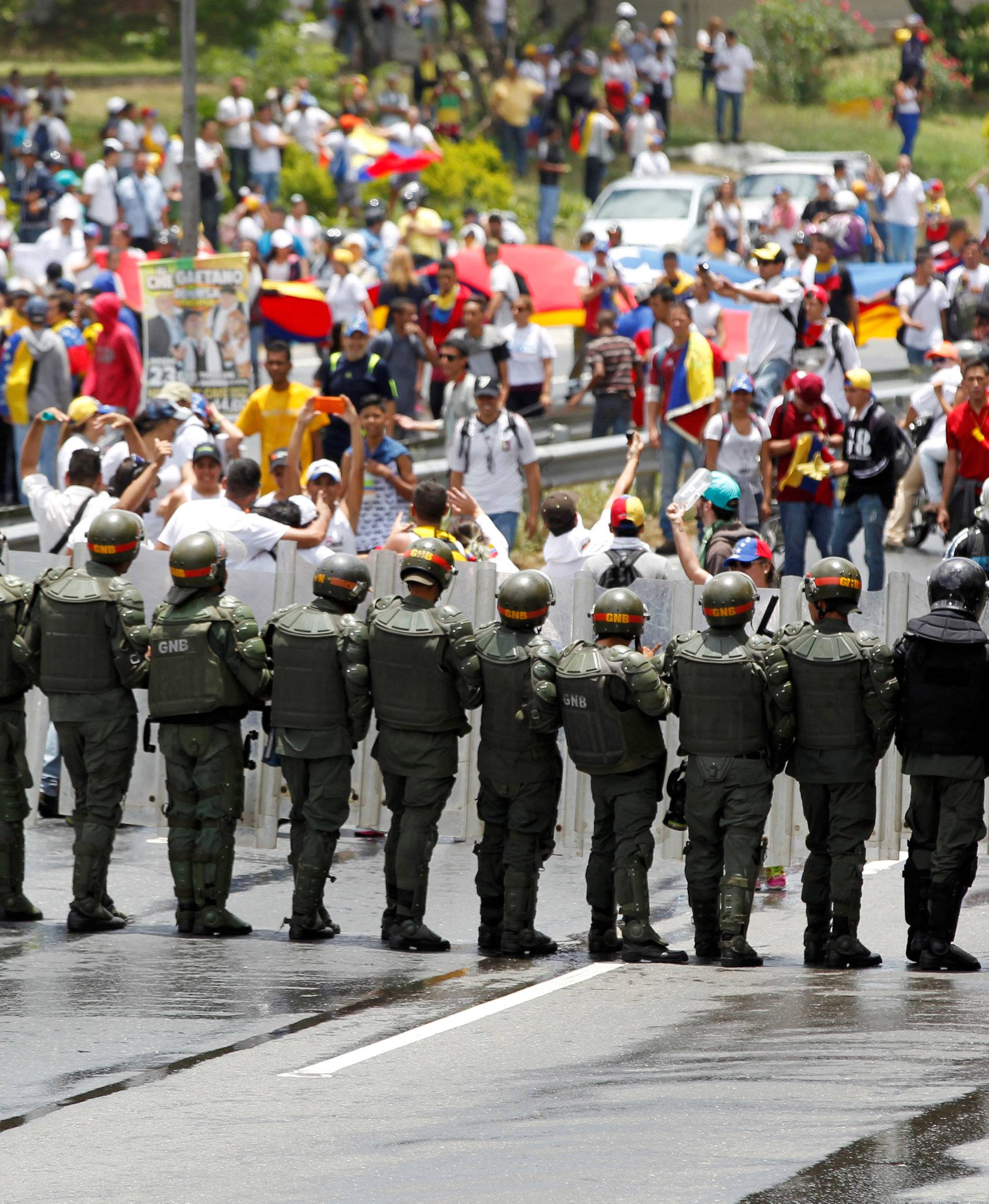 Police officers block the street as opposition supporters take part in a rally to demand a referendum to remove Venezuela's President Nicolas Maduro, in Caracas, Venezuela,