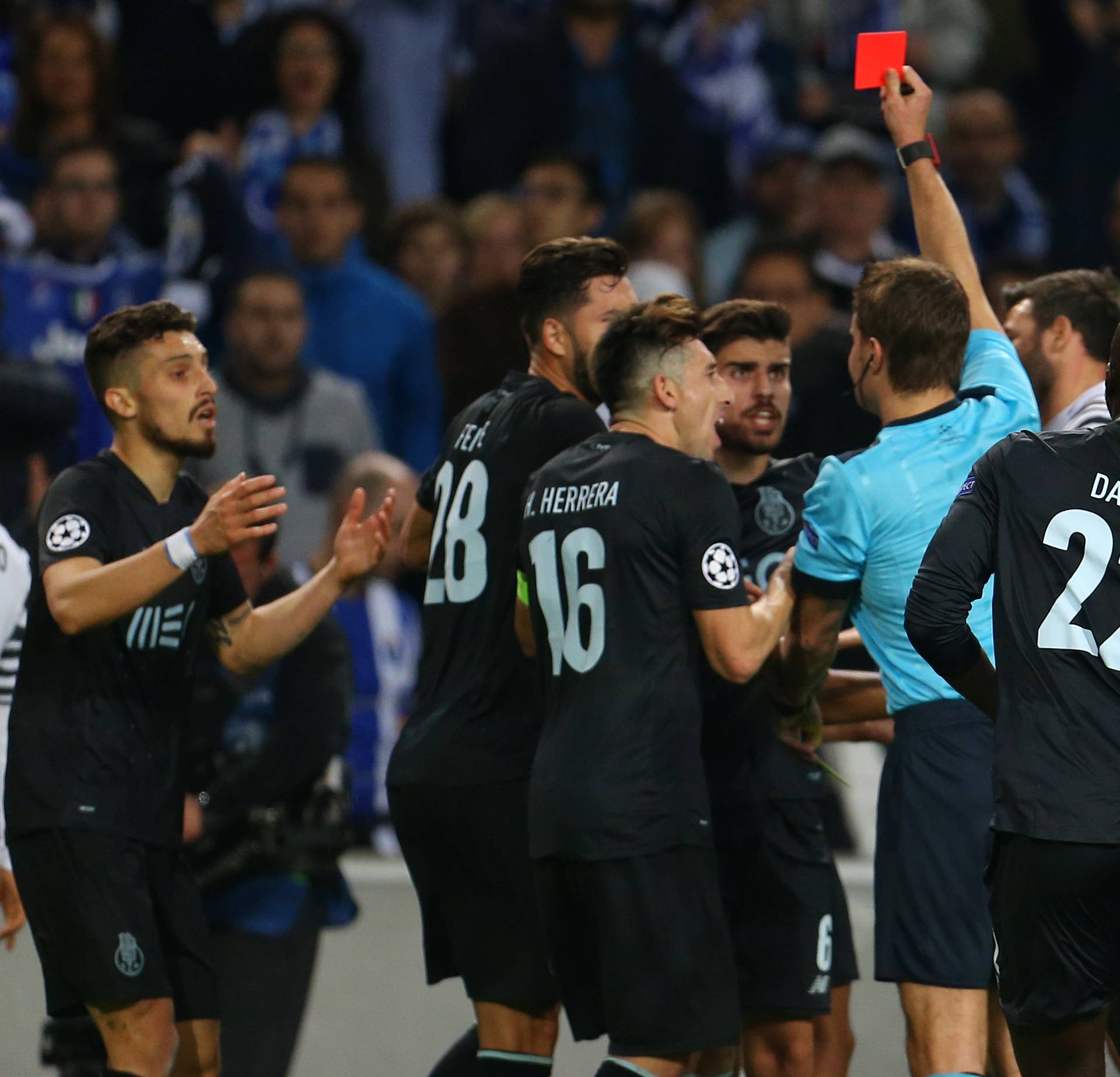 Referee Felix Brych shows a red card to FC Porto's Alex Telles
