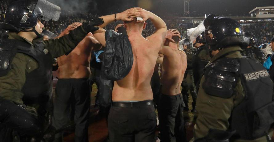 Police escort the soccer fans injured during the fights at a match between Red Star and Partizan in Belgrade