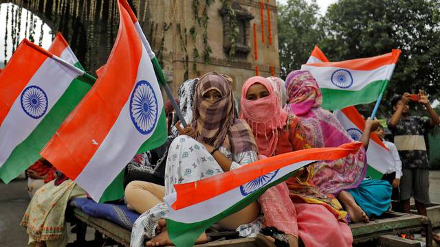 Women wave national flags as they take part in India's Independence Day celebrations in Ahmedabad