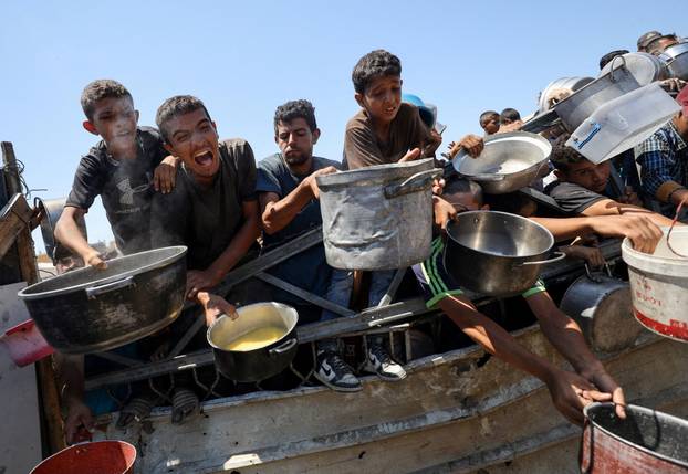 Palestinians receive food from charity kitchen, in Gaza City