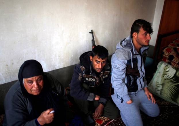 Azad Hassan and his brother Mohammad, whose hands were chopped off by Islamic State militants, sit with their aunt in a house at Nimrud village, south of Mosul