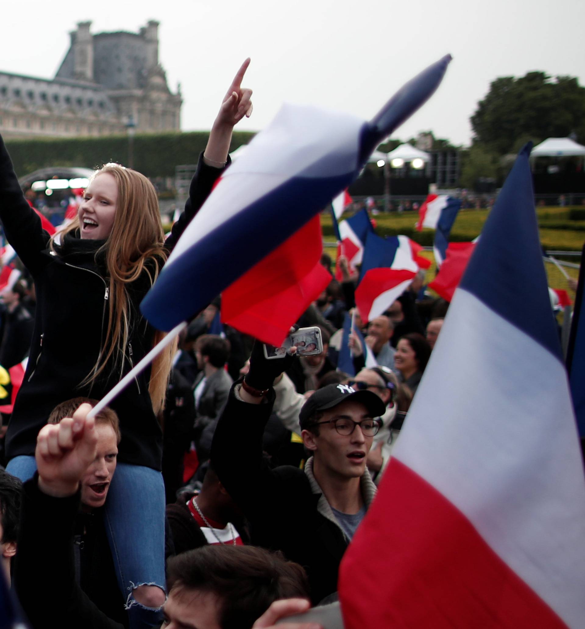 Supporters of Emmanuel Macron celebrate near the Louvre museum after results were announced in the second round vote of the 2017 French presidential elections, in Paris