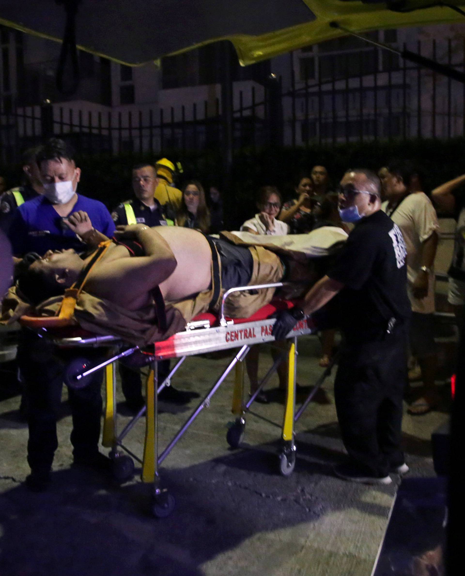 An injured hotel guest is seen outside of a hotel after a shooting incident inside Resorts World Manila in Pasay City, Metro Manila