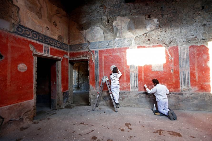Archaeologists work on  a fresco in the House of Lovers "Casa degli Amanti\