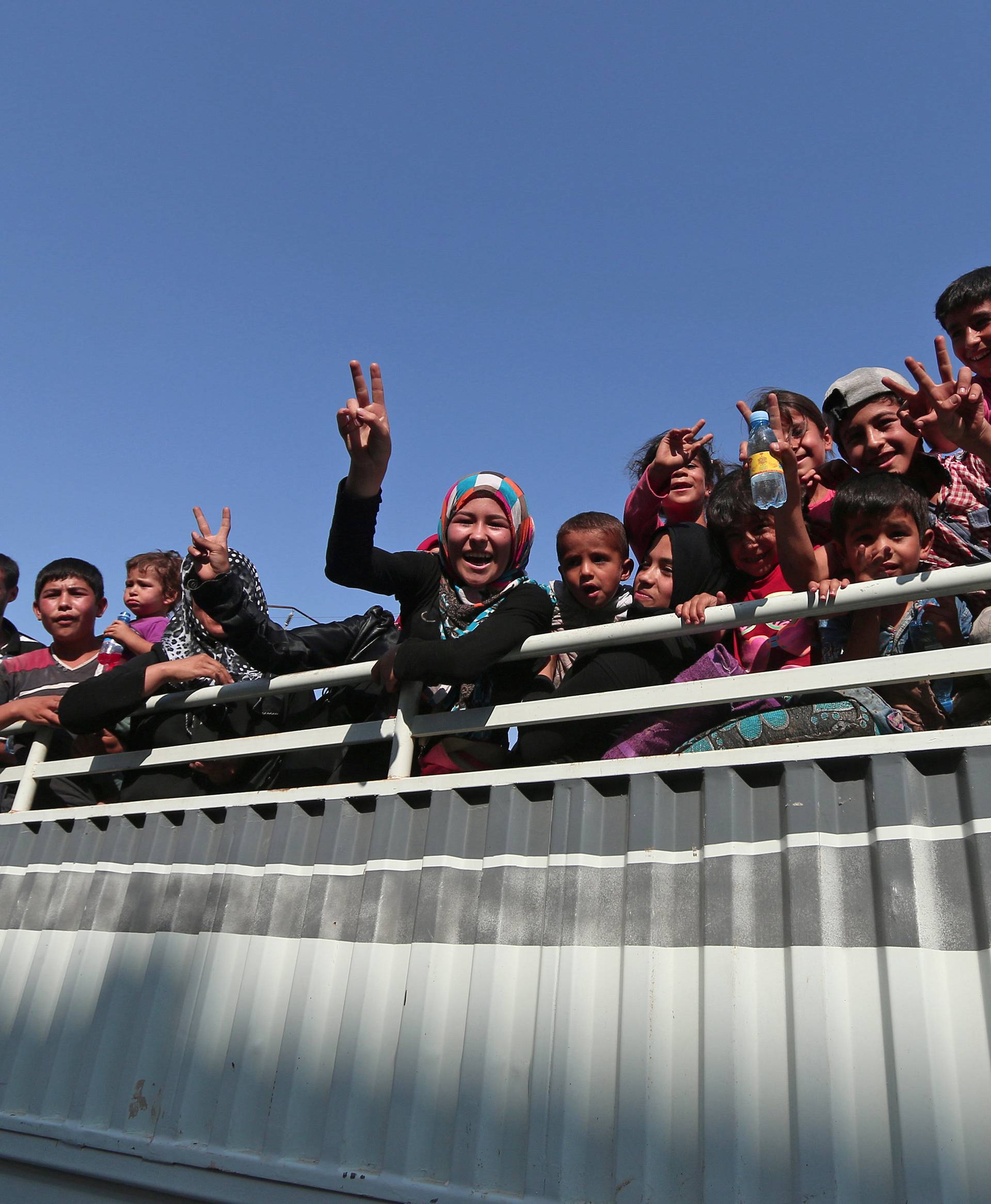 Civilians react atop of a pick-up truck after they were evacuated by the Syria Democratic Forces (SDF) fighters from an Islamic State-controlled neighbourhood of Manbij