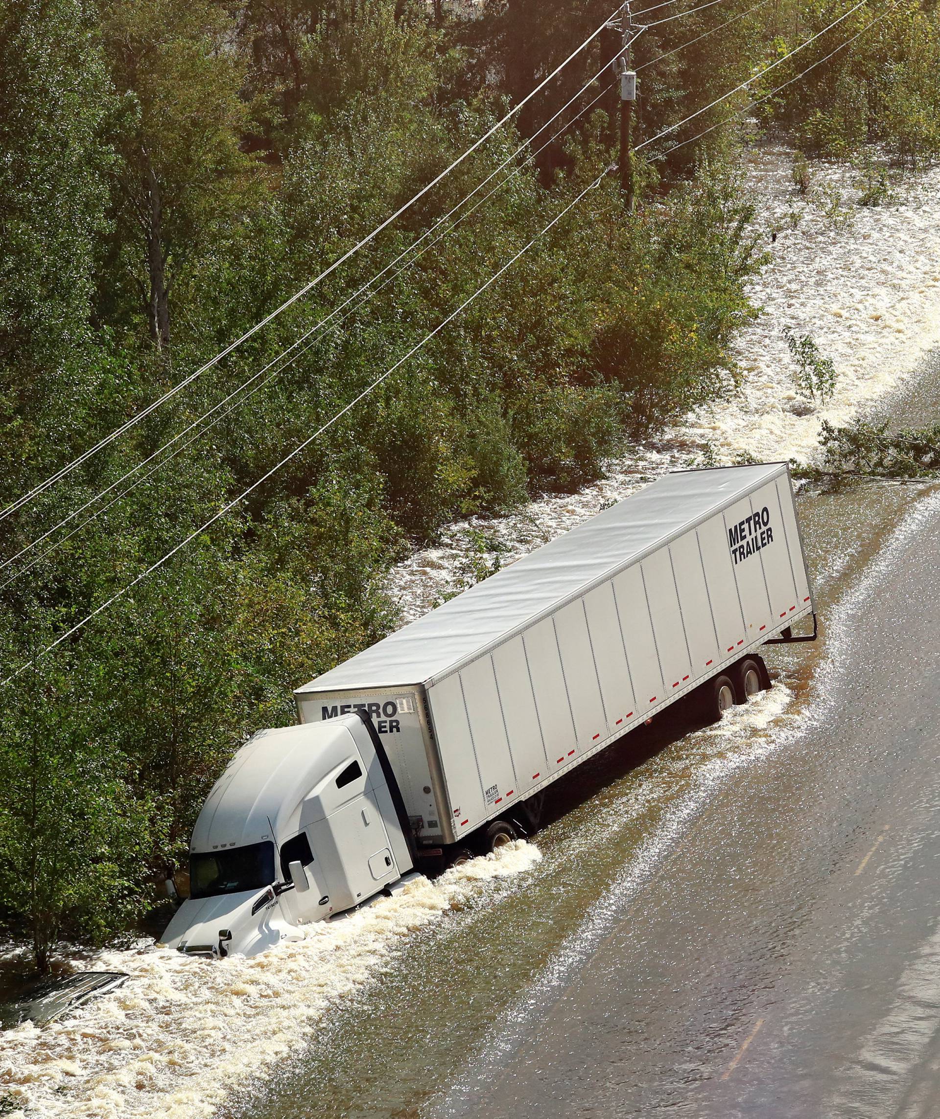 A tractor trailer sits on its side after being washed over Route 301 from flood waters caused by Hurricane Florence near Dillon, South Carolina