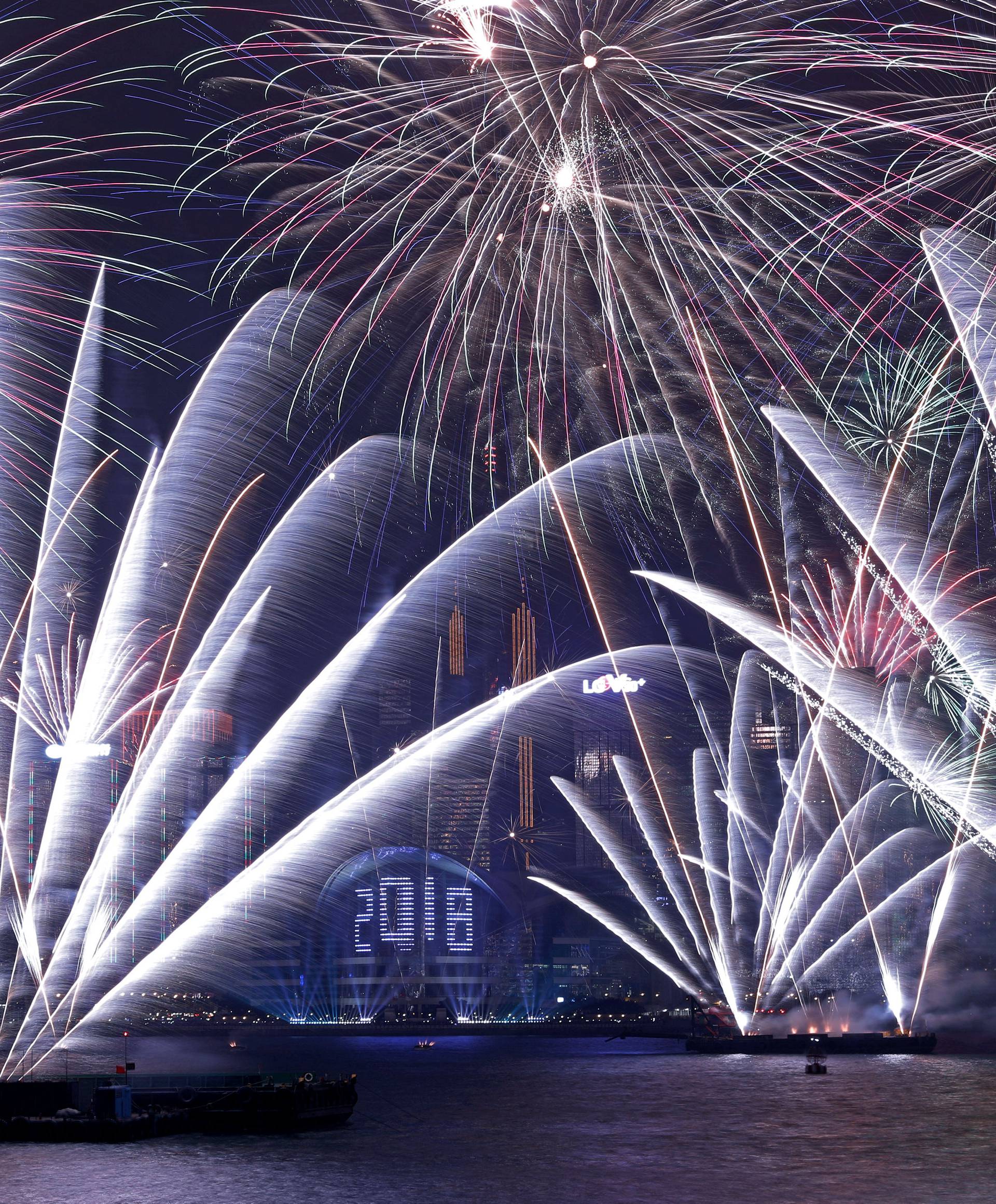 Fireworks explode over Victoria Harbour and Hong Kong Convention and Exhibition Centre during a pyrotechnic show to celebrate the New Year in Hong Kong
