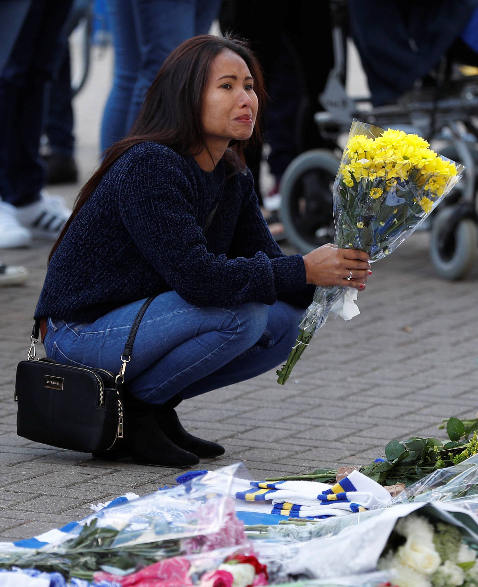 Leicester City football fans pay their respects outside the football stadium, after the helicopter of the club owner Thai businessman Vichai Srivaddhanaprabha crashed when leaving the ground on Saturday evening after the match, in Leicester