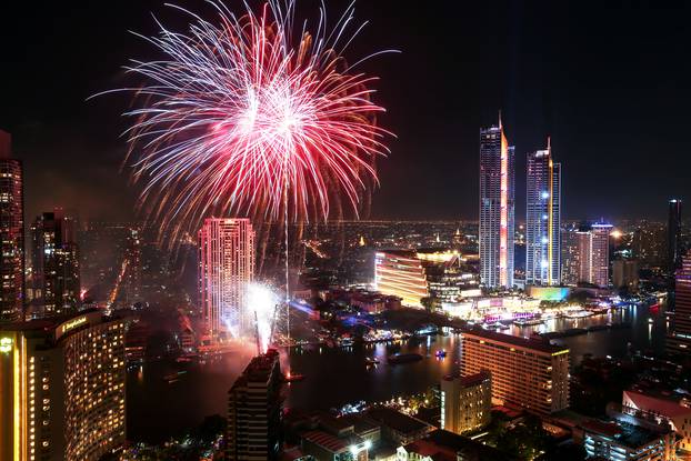 Fireworks explode over Chao Phraya River during the New Year celebrations in Bangkok