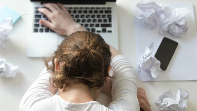 Top view portrait of woman lying at desk near the laptop