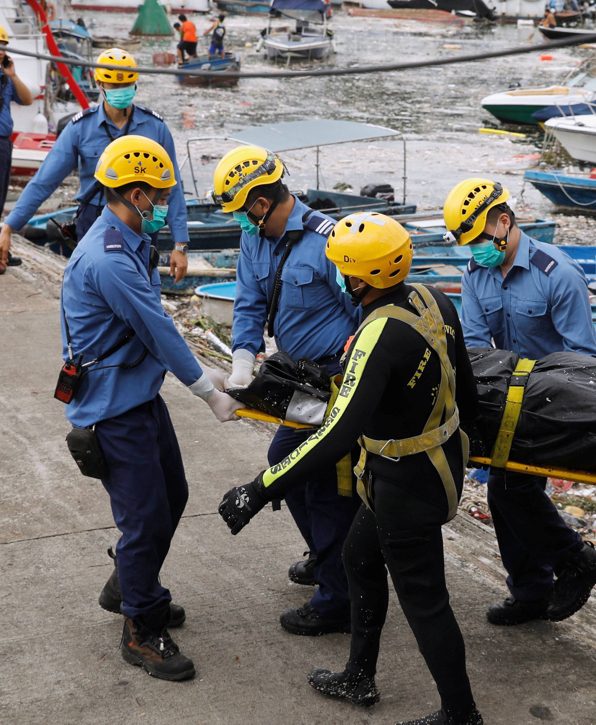 Firemen carry a covered body near the Sai Kung Hoi Pong Street waterfront after Super Typhoon Mangkhut hit Hong Kong