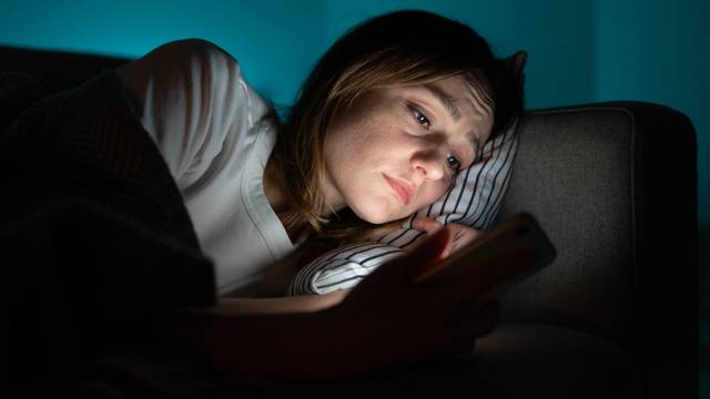 Unhappy,Woman,Lying,In,Bed,With,Smartphone,,Following,Ex-boyfriend,On