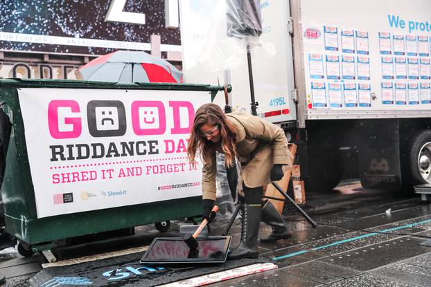 Allison Hagendorf mashes computer parts with a hammer during the National Good Riddance day ceremonial shredding of bad memories of 2018 in Times Square