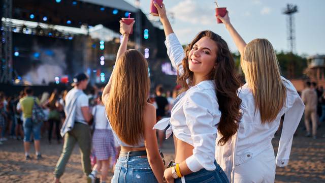 Girls,With,Drinks,Enjoy,Live,Music,At,Sunny,Beach,Festival.