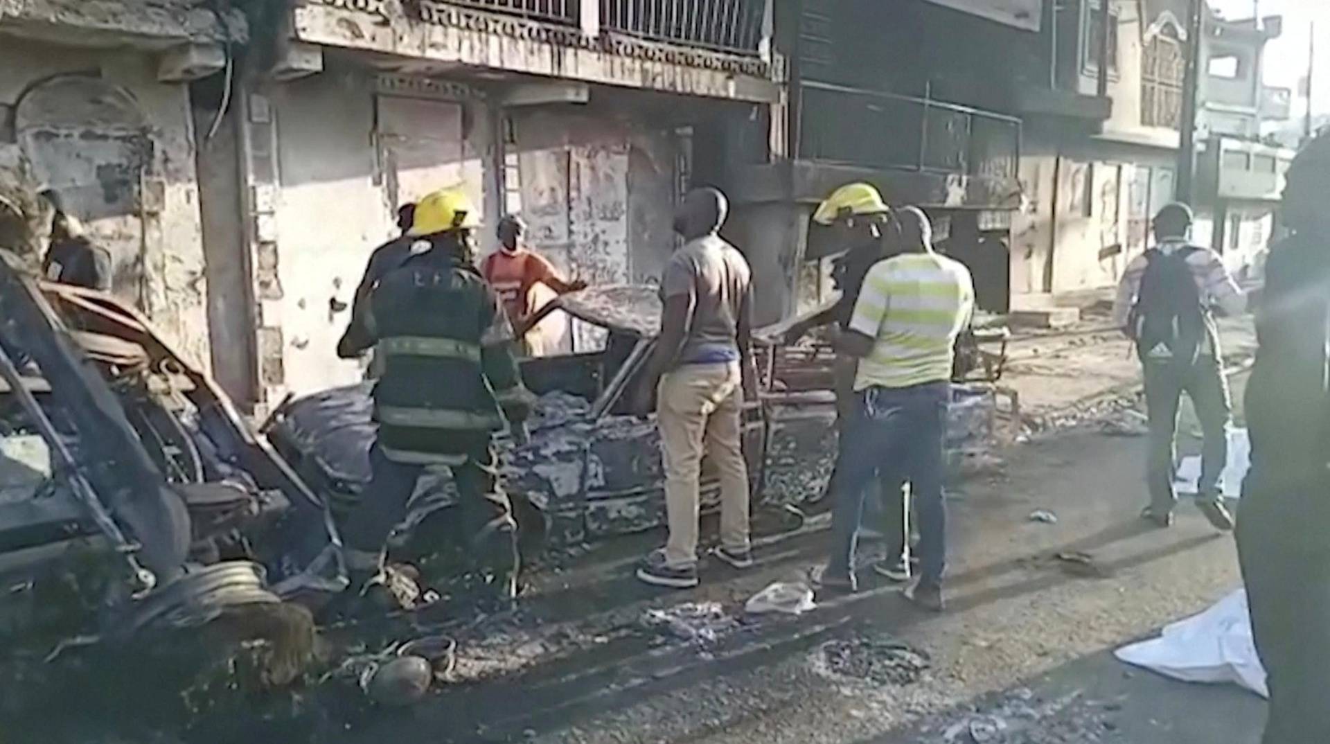 People stand at the site of an explosion in Cap-Haitien