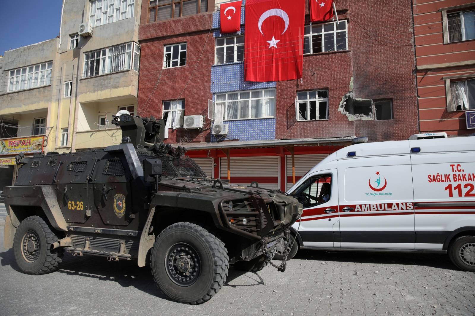 Police vehicle and an ambulance are seen outside of a building after it was hit by mortar shells fired from Syria, in the Turkish border town of Akcakale