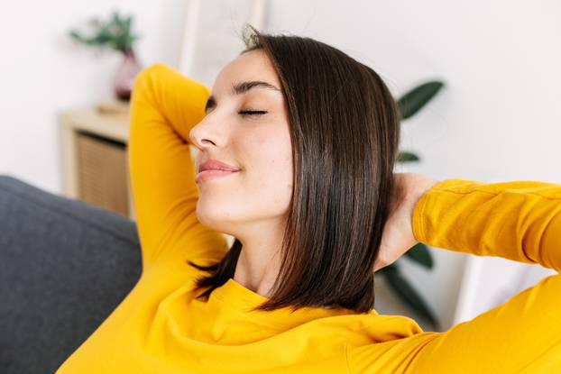 Closeup portrait of young beautiful woman lying on couch at home