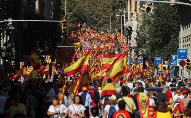 People wave Spanish and Catalan flags as they attend a pro-union demonstration organised by the Catalan Civil Society organisation in Barcelona