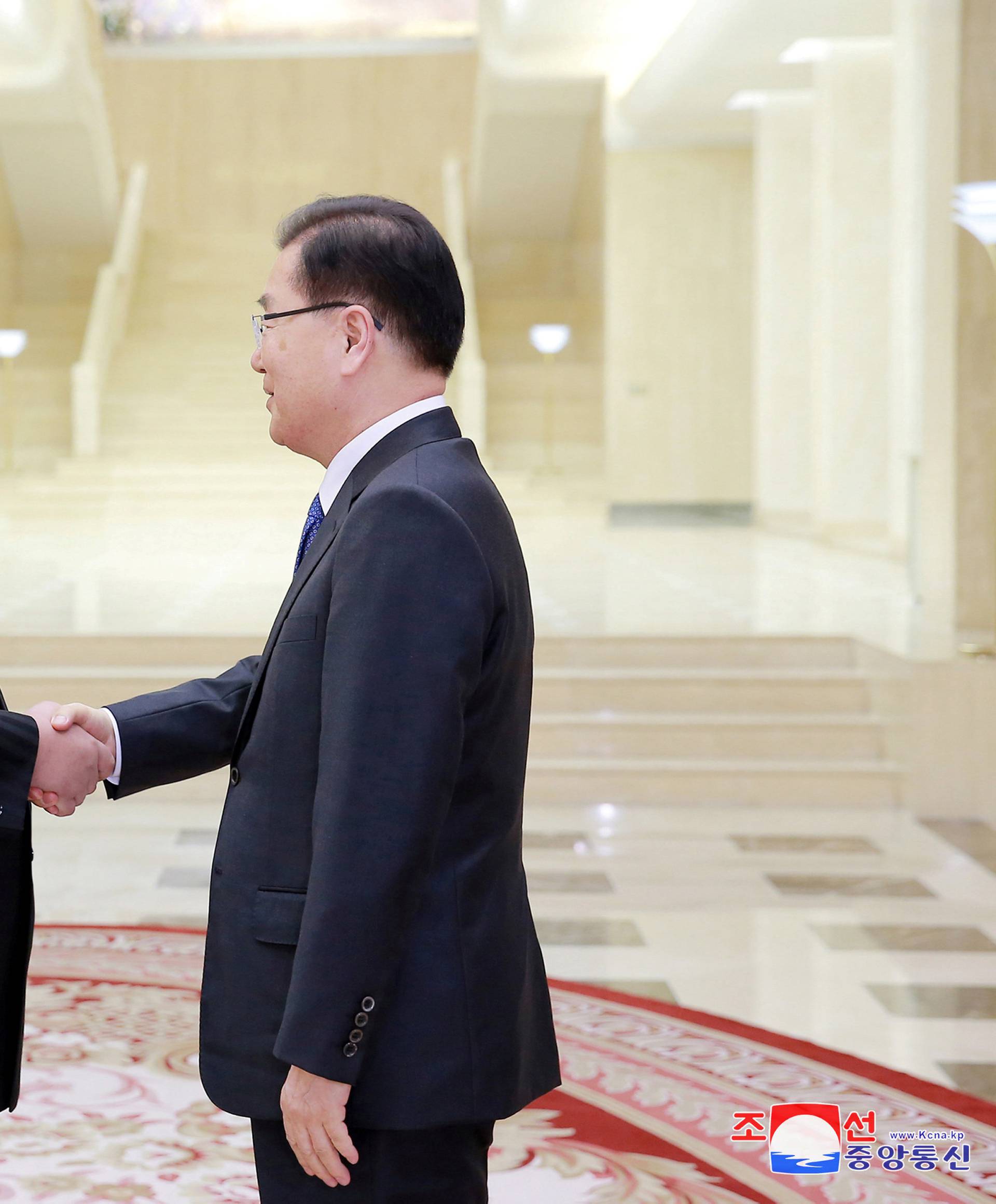 North Korean leader Kim Jong Un shakes hands with Chung Eui-yong in this photo released by North Korea's Korean Central News Agency