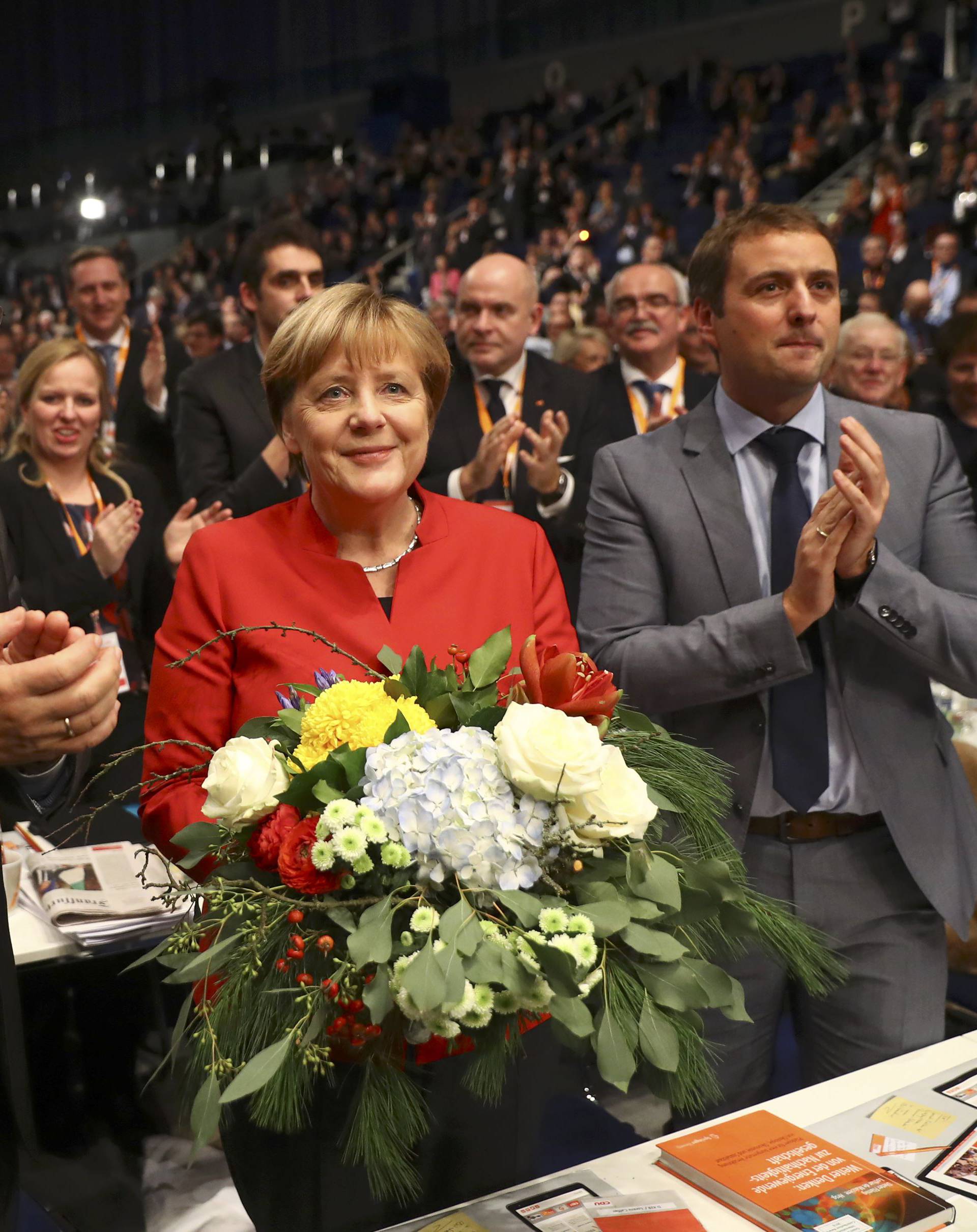 German Chancellor and leader of the conservative CDU Merkel reacts after she was re-elected as chairwoman at the CDU party convention in Essen