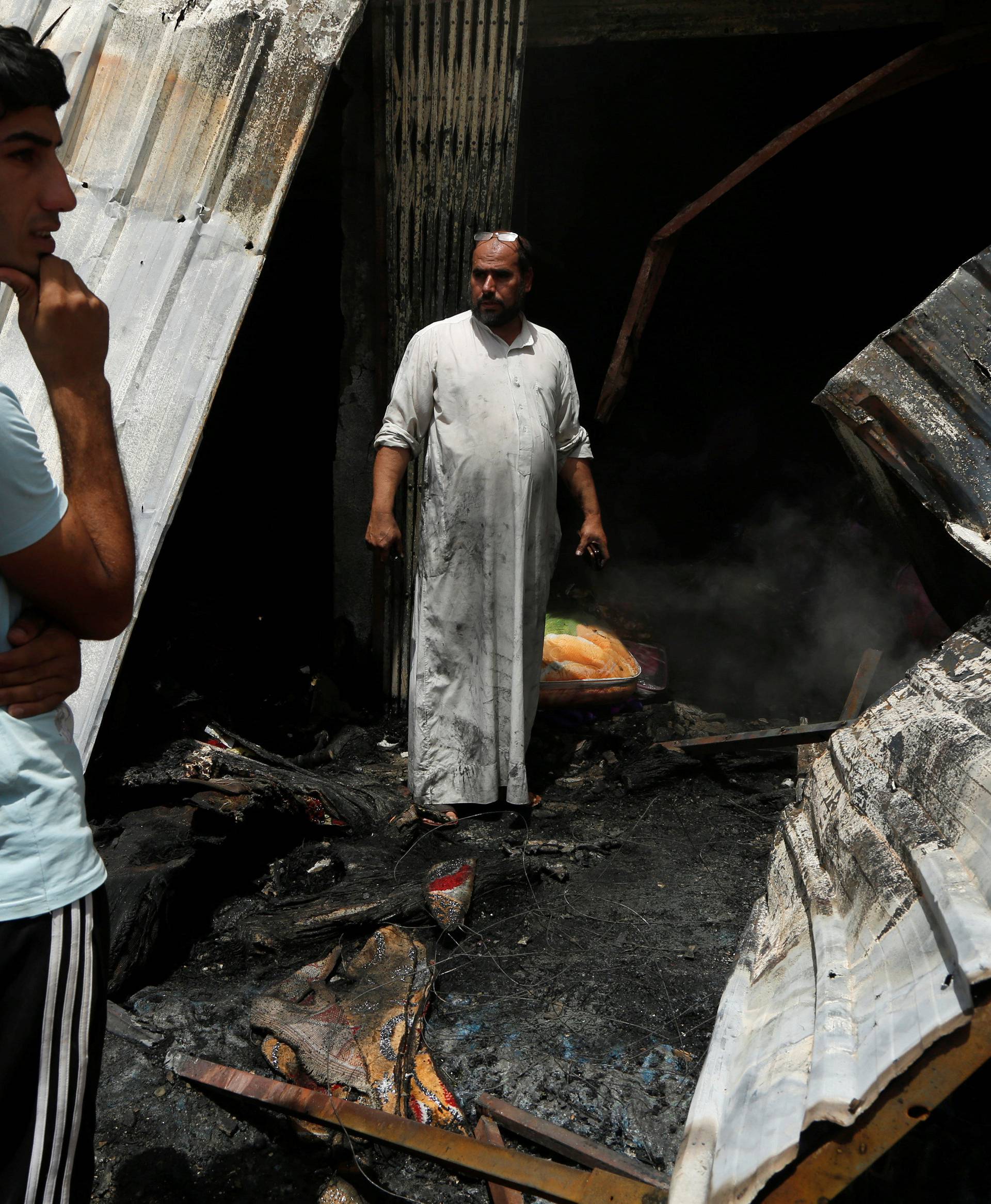 People gather at the scene of a car bomb attack in Baghdad's mainly Shi'ite district of Sadr City