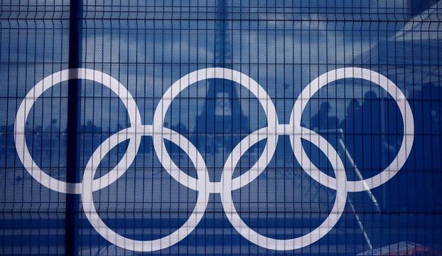 The Eiffel Tower is seen through a net with a part of the logo of the Paris 2024 Olympic and Paralympic Games from the Trocadero square in Paris