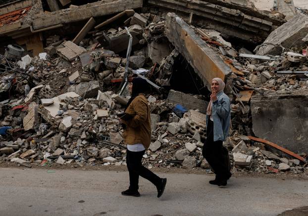 People cross a damaged bridge in Zrarieh