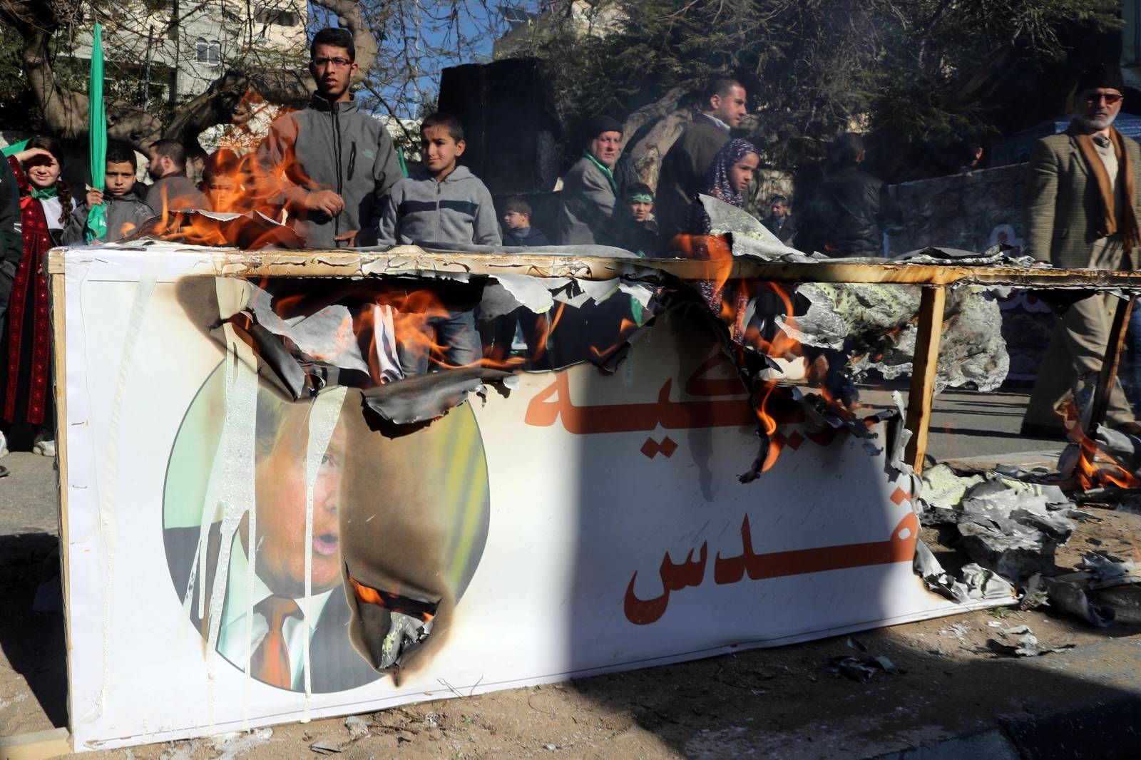 Palestinian Hamas supporters burn a model of a coffin representing the U.S. embassy in Jerusalem with a picture of U.S. President Donald Trump, during a rally in Gaza